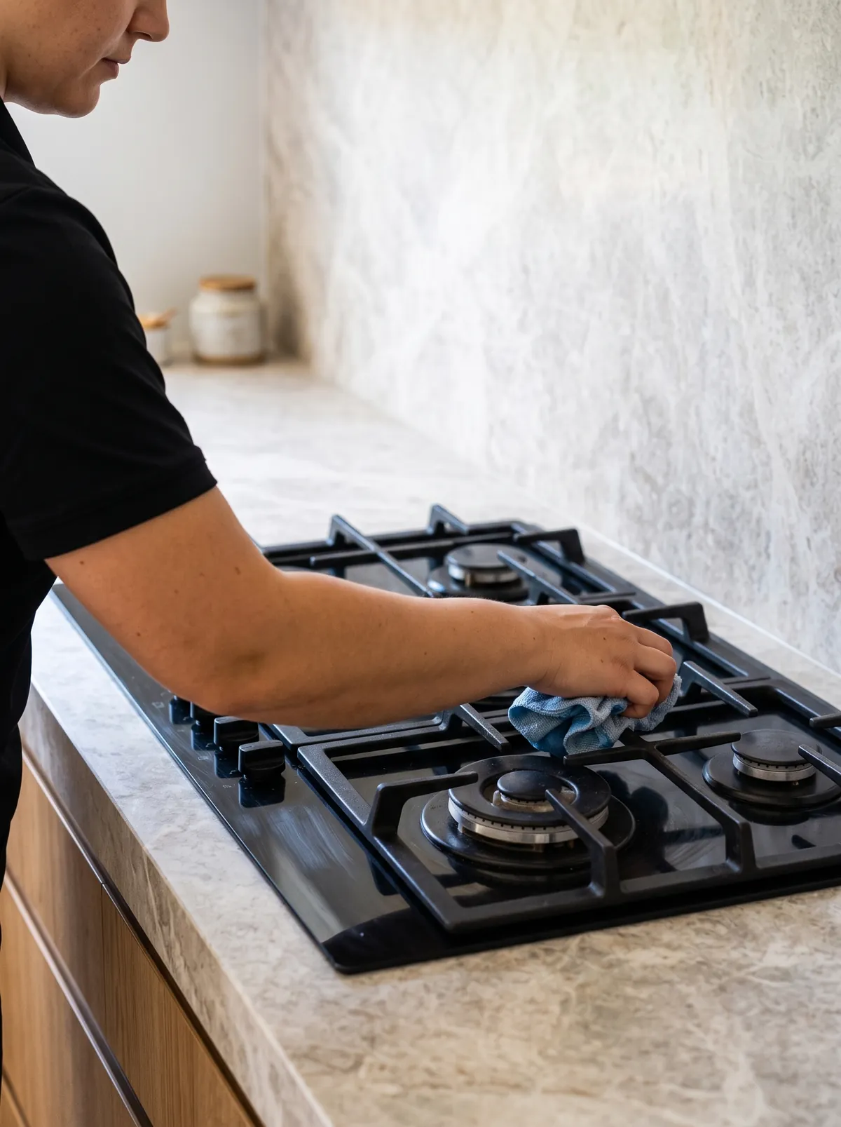 Detailing a gas cooktop beside a stone splashback
