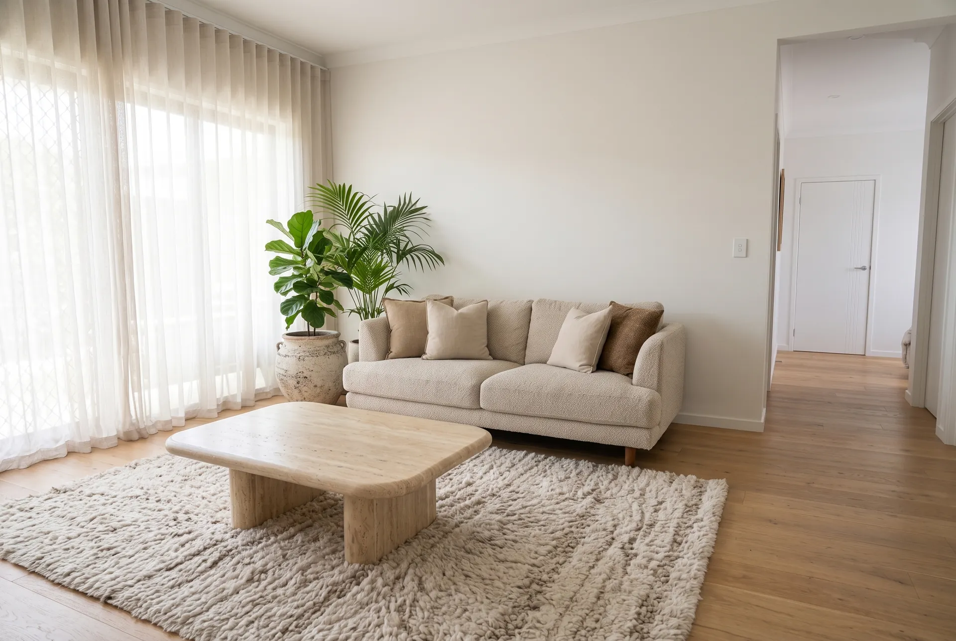 A tidy living room with a linen sofa and stone coffee table