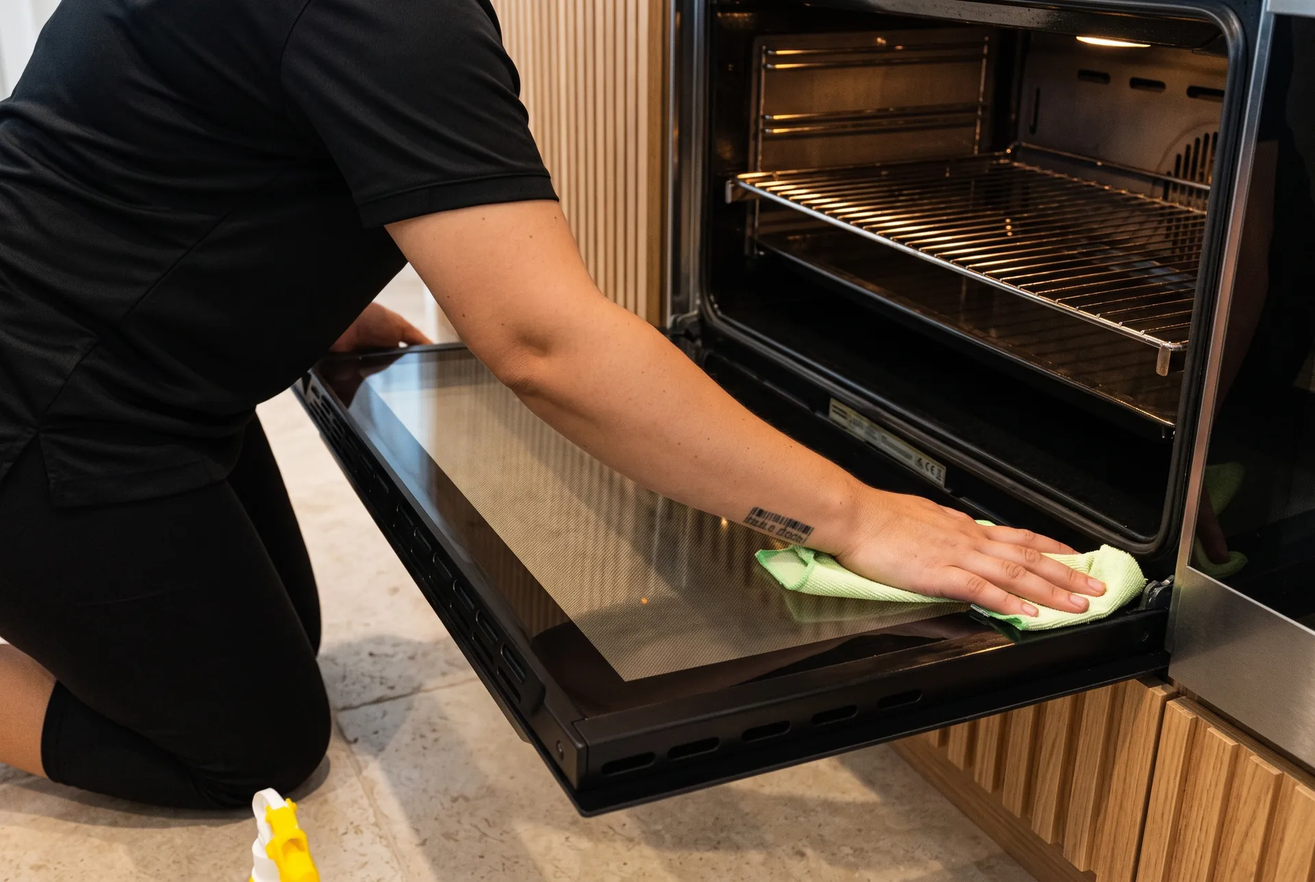 Cleaning the glass of an open oven door